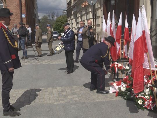 Obchody Święta Konstytucji 3 Maja w Szczecinku - kwiaty pod tablicą