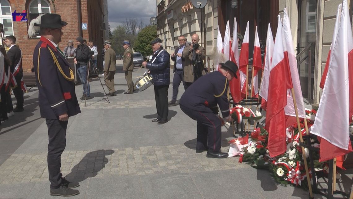 Obchody Święta Konstytucji 3 Maja w Szczecinku - kwiaty pod tablicą